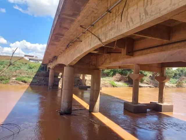 Concrete piers and beams of a bridge over a river.